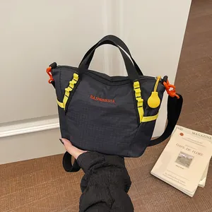 Handheld view of a minimalist black grid-patterned fashion yoga bag with yellow accents