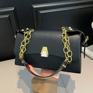 Close-up detail of a sleek black square shoulder bag with gold chain and clasp