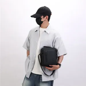 Model wearing a stylish black crossbody messenger bag with striped shirt