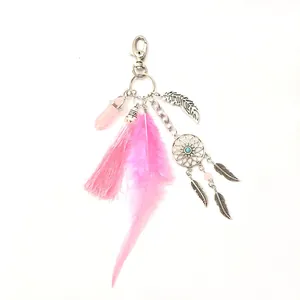 Detailed macro view of Bohemian style dreamcatcher keychain with pink tassels and soft feathers