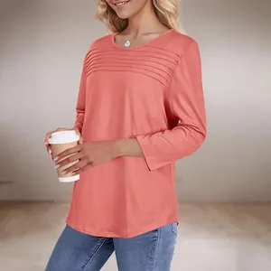 Detail von plissiertem Rundhalsausschnitt und 3/4-Ärmeln an korallfarbenem Damen-T-Shirt