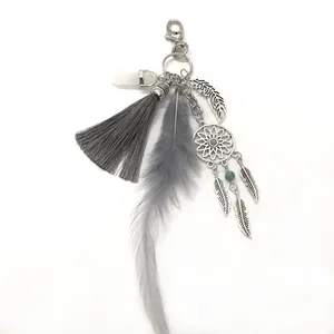 Detailed view of bohemian dreamcatcher keychain with grey tassel and feather charms.