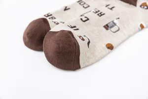 Close-up of cotton socks featuring a coffee cup and bean pattern in beige and brown