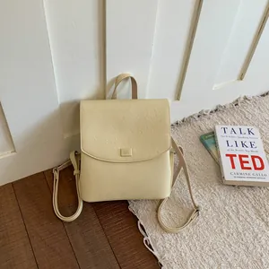 Stylish creamy yellow textured women's backpack displayed on a minimalist indoor rug