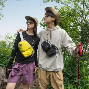 Outdoor lifestyle shot of yellow and black crossbody chest bags for hiking and travel.