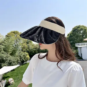 Εξωτερική όψη γυναίκας που φοράει ένα κομψό μαύρο και μπεζ καπέλο με φαρδύ γείσο