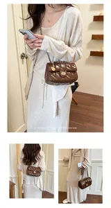 Detailweergave van een retro bruine gewatteerde tas met ketting in minimalistische stijl