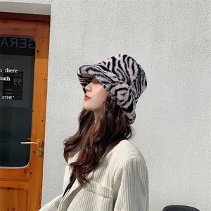 Profil d'un mannequin portant un chapeau bob en peluche à motif zèbre contre un mur.