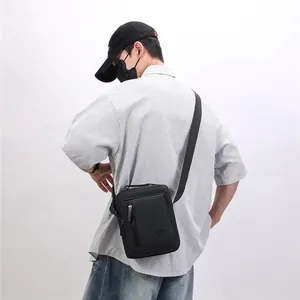 Back view of a black large capacity crossbody messenger bag worn by a model