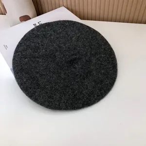 Detailed texture of a classic charcoal gray wool felt beret for women's winter style