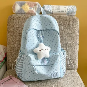 Close-up of light blue star pattern backpack with plush star charm and striped side pockets