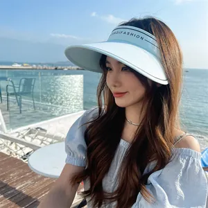 Femme asiatique portant une élégante visière de soleil bleu clair à bord large à la mer