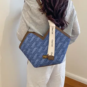 Detailansicht einer gewebten Tragetasche mit blauer Textur und Logo-Riemen am Model.