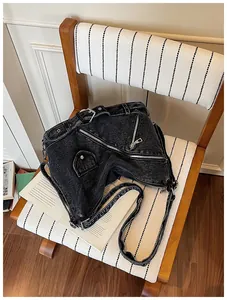 Gros plan d'un sac bandoulière en denim noir avec des éléments de veste de moto