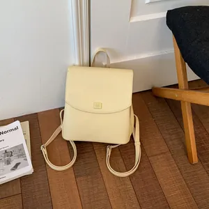 Minimalist cream yellow women's faux leather backpack in a cozy lifestyle setting