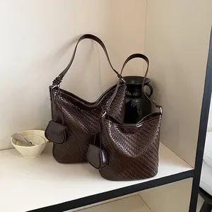 Close-up detail of dark brown woven large shoulder hobo and bucket bag set with mini pouches