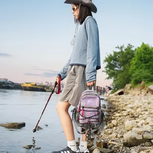 Lifestyle-Ansicht eines leichten lila-grauen Outdoor-Wanderrucksacks an einem felsigen Flussufer