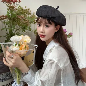 Asian model wearing a stylish black vintage frayed beret hat in a bright lifestyle setting