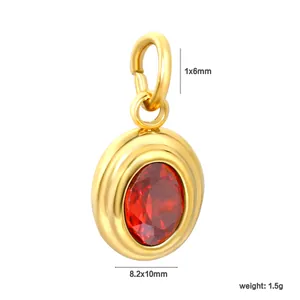 Vue détaillée d'un pendentif ovale en acier inoxydable doré avec une pierre rouge.