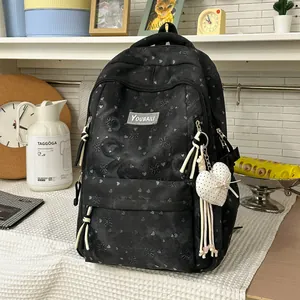 Close-up view of a black high-capacity student backpack with cute heart patterns and keychain