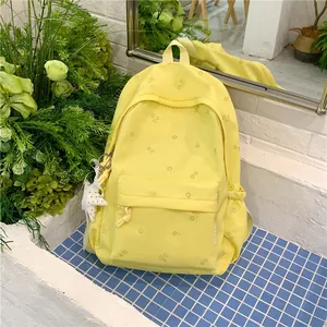 Bright yellow student backpack featuring small floral patterns and star charm detail