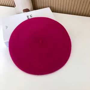 Top-down view of a vibrant magenta wool beret showing soft felt texture and classic design