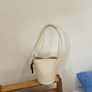 Gesamtansicht der cremefarbenen geflochtenen Beuteltasche mit geflochtenem Riemen