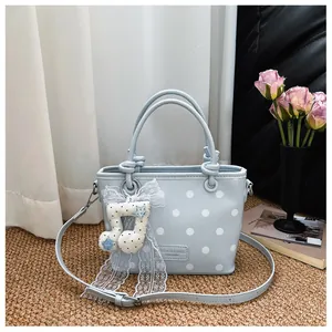 Light blue leather polka dot handbag for women with cute musical note charm detail.