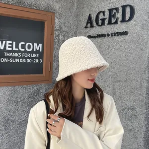 Side view of a woman wearing a white lamb wool bucket hat in a trendy street scene