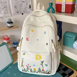 Dettaglio dello zaino bianco sporco con ricami di fiori e farfalle vivaci e colorati