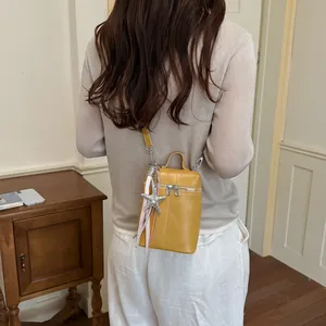 Elegante borsa a tracolla gialla per cellulare con ciondolo a stella marina in scena
