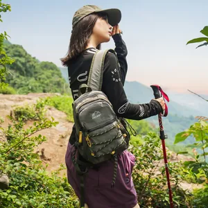 Frau trägt einen leichten grünen Wanderrucksack beim Trekking in den Bergen im Freien