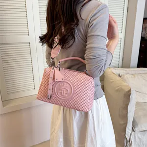 Modische rosa gewebte Handtasche mit dekorativem Logo-Riemen, getragen von einem Model.