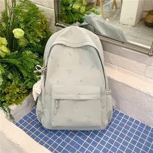 Fresh light green backpack with floral pattern and polka dot ribbon charm details