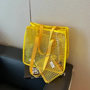 Detailed view of yellow mesh tote bag and small pouch on a book and black leather sofa