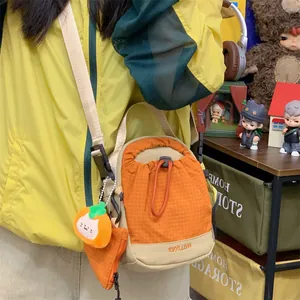 Gros plan d'un sac de téléphone bandoulière léger orange à cordon pour la randonnée loisir