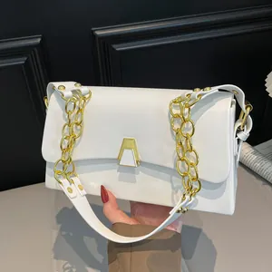 Close-up of white crossbody square bag with stylish gold chain strap and metal clasp