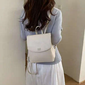 Back view of a woman wearing a minimalist beige leather backpack for casual commuting