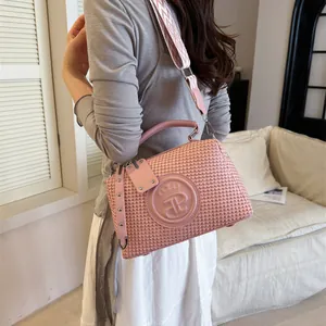 Modische rosa gewebte Handtasche mit geometrischem Gurt, an einem Model präsentiert