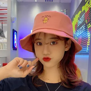 Cute pink bucket hat with 'MR. POTATO' embroidery worn by a model in a trendy setting