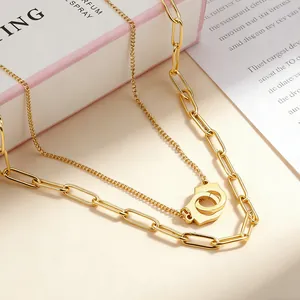Close-up of double-layered gold-plated stainless steel necklace with handcuff pendant.