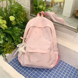 Macro view of pink floral school backpack with star charm in a fresh garden setting
