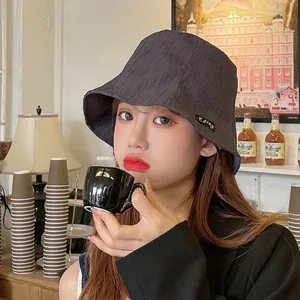 Stylish dark grey wrinkled bucket hat for women in a vintage cafe setting atmosphere