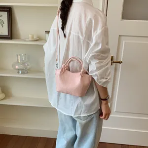 Close-up detail view of a stylish pink faux leather bow-knot shoulder bucket bag