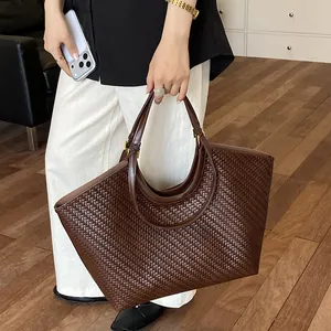 Lifestyle view of a large brown woven tote bag with intricate texture and minimalist design