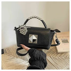 Close-up of black crinkle leather small square bag with metallic bead handle detail