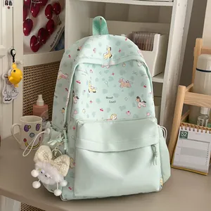 Mint green student backpack with cute cartoon pony prints in a cozy room setting