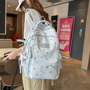 Close-up of a light blue star-patterned backpack worn by a model in a casual setting.