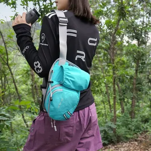 Detailed view of a cyan outdoor sling bag with a water bottle pocket worn by a female hiker