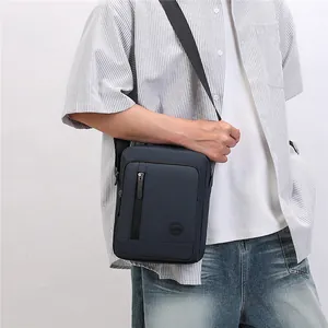 Male model wearing a navy blue casual crossbody small square bag with zipper pocket